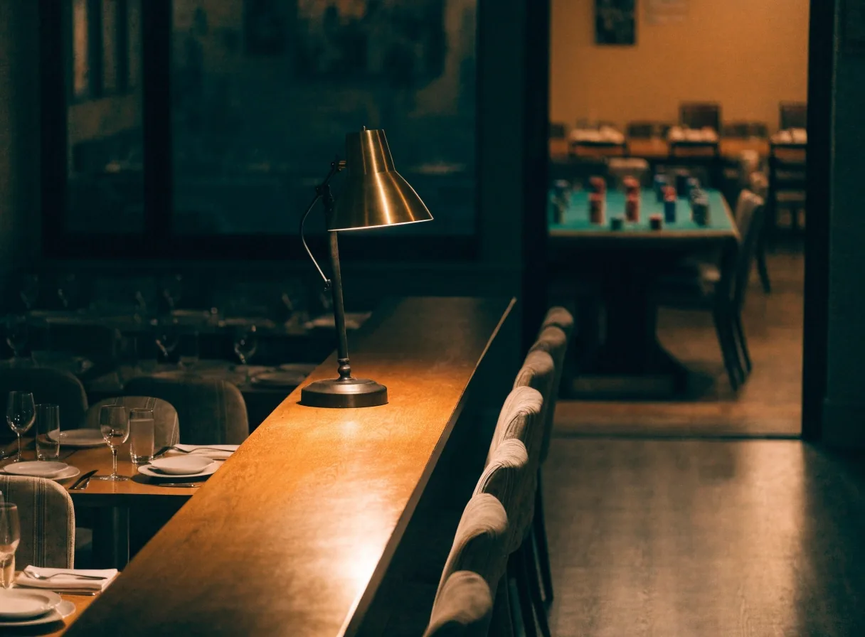 Cicha sala restauracji po wieczornej obsłudze, nakryty stół w ciepłym świetle