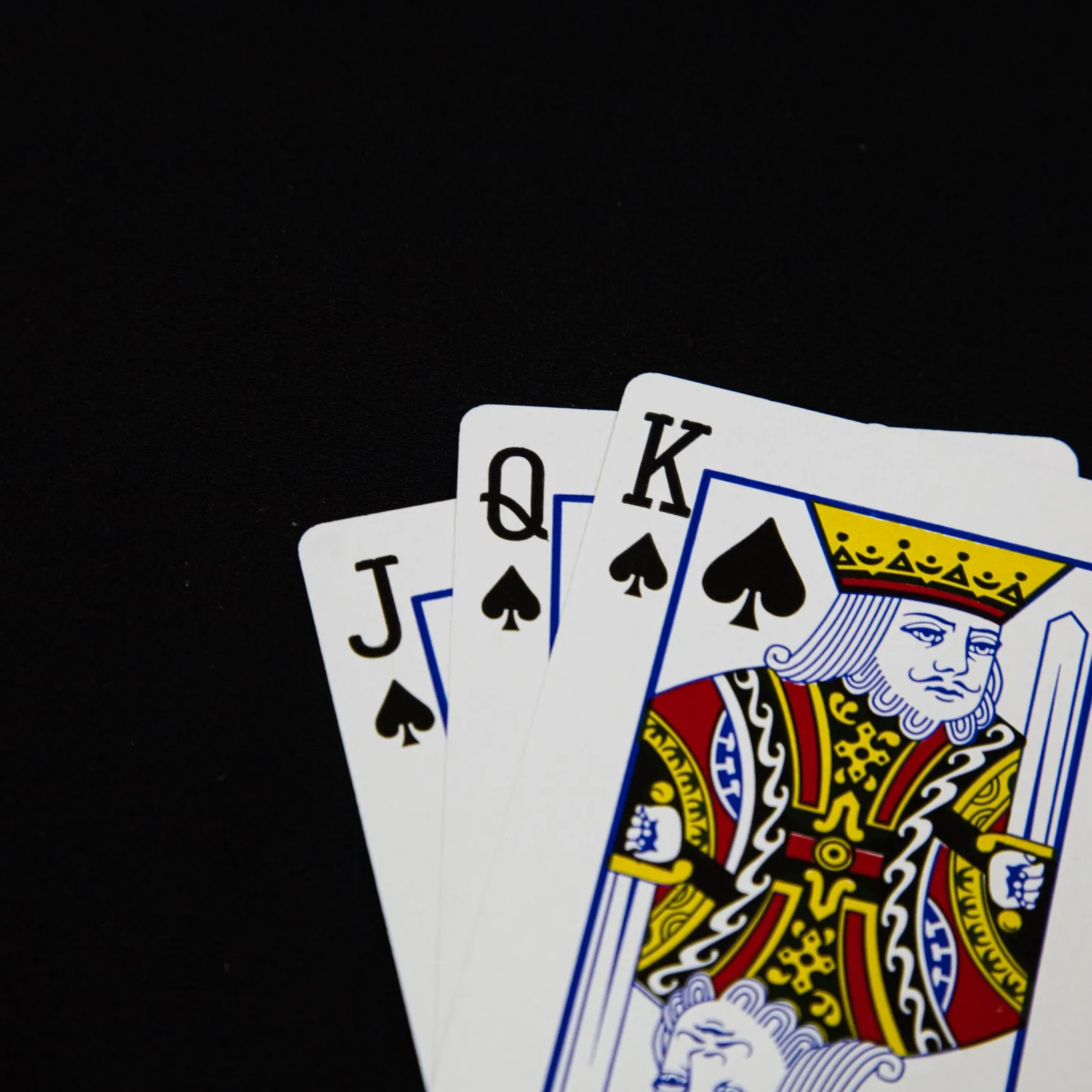 Zbliżenie na stosy żetonów pokerowych w kilku kolorach ułożonych na zielonym suknie stołu